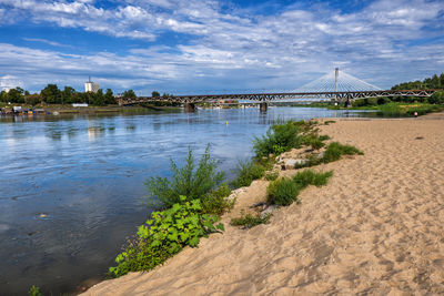 Scenic view of river against cloudy sky