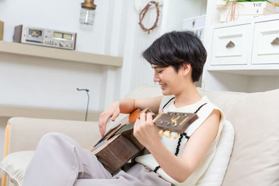 Young woman playing violin at home