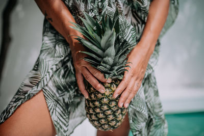 Midsection of woman holding plant