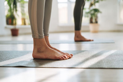 Young fit women practice yoga doing asana in a bright yoga studio