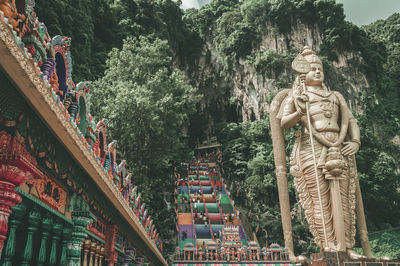 Statue against trees and building