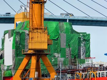 Low angle view of cranes against sky