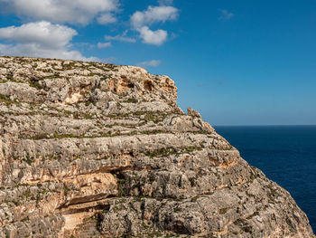 Rock formations by sea against sky