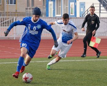 Group of people running on soccer field