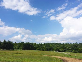 Scenic view of grassy field against cloudy sky