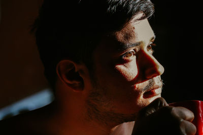 Close-up portrait of young man looking away