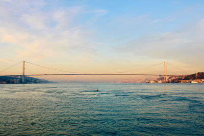 Suspension bridge over sea against sky