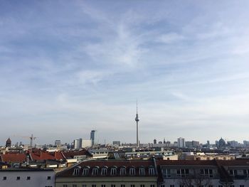 View of cityscape against cloudy sky