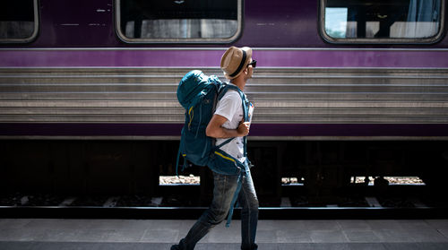 Rear view of man working at railroad station