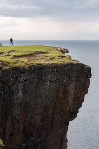 Rock formations by sea against sky