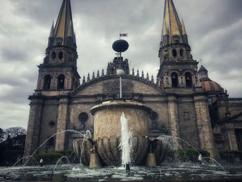 Low angle view of bridge over river against buildings