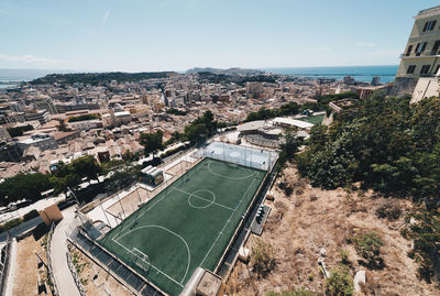 High angle view of soccer field and buildings in city