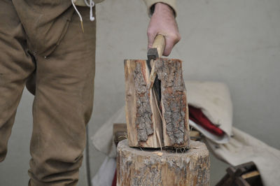 Midsection of man chopping wood