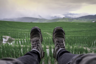 Low section of person wearing shoes on field