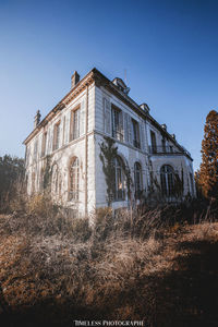 Low angle view of old building against clear blue sky