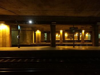 Illuminated railroad station platform at night