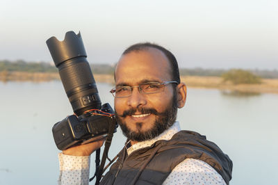 Portrait of photographer with his dslr camera.