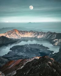 Scenic view of sea and snowcapped mountains against sky