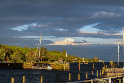 Sailboats moored on sea against sky