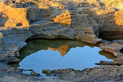 Reflection of beach structure in water at see coves