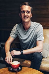 Portrait of young man sitting on table