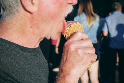 Midsection of man having ice cream at outdoors