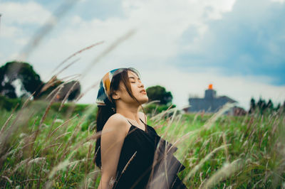 Woman standing on field against sky