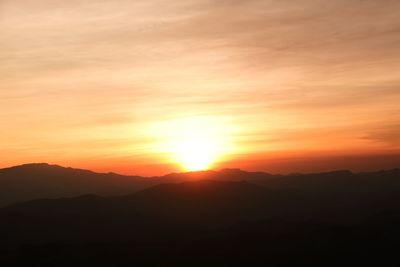 Scenic view of silhouette mountains against romantic sky at sunset