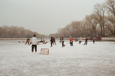 Group of people on snowy landscape against sky