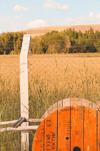 Wooden fence on field against sky