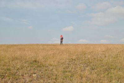 Woman standing on field against sky