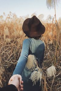 Rear view of woman sitting on field