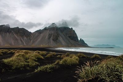 Scenic view of sea and mountains against sky