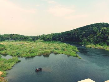 High angle view of river amidst trees against sky