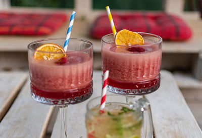 Close-up of cocktails in vintage glasses on white pallet table in bar