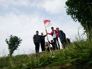 Friends standing on grassy field