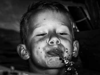 Close-up of boy spraying water outdoors