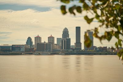 View of city by river against buildings