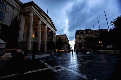 Buildings in city against cloudy sky