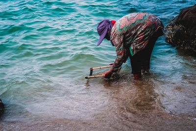 Rear view of woman fishing in sea