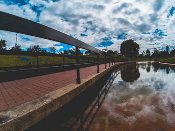 Reflection of trees in swimming pool against sky