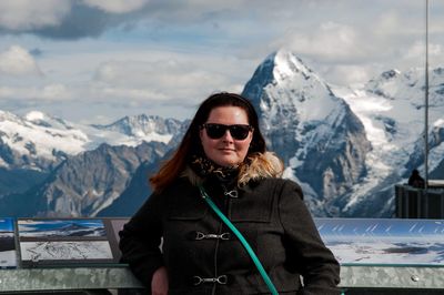 Portrait of woman against snowcapped mountains during winter