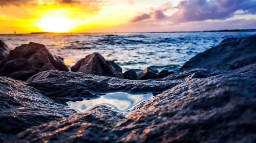 Scenic view of sea against dramatic sky during sunset