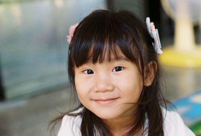 Close-up portrait of smiling girl with bangs