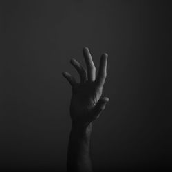 Close-up of human hand over black background