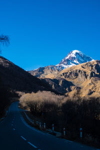 Scenic view of snowcapped mountains against clear blue sky