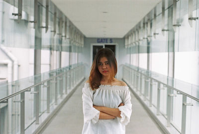 Portrait of woman standing against railing in building