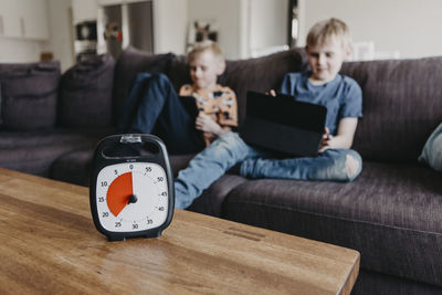Boys spending time with laptop according to clock