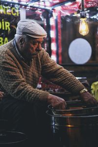Man holding food at market stall at night