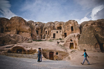 People standing in front of old ruins